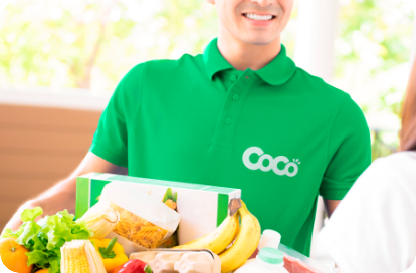 Empleado vestido con un remera verde con el logo de Coco entregando mercadería a una persona